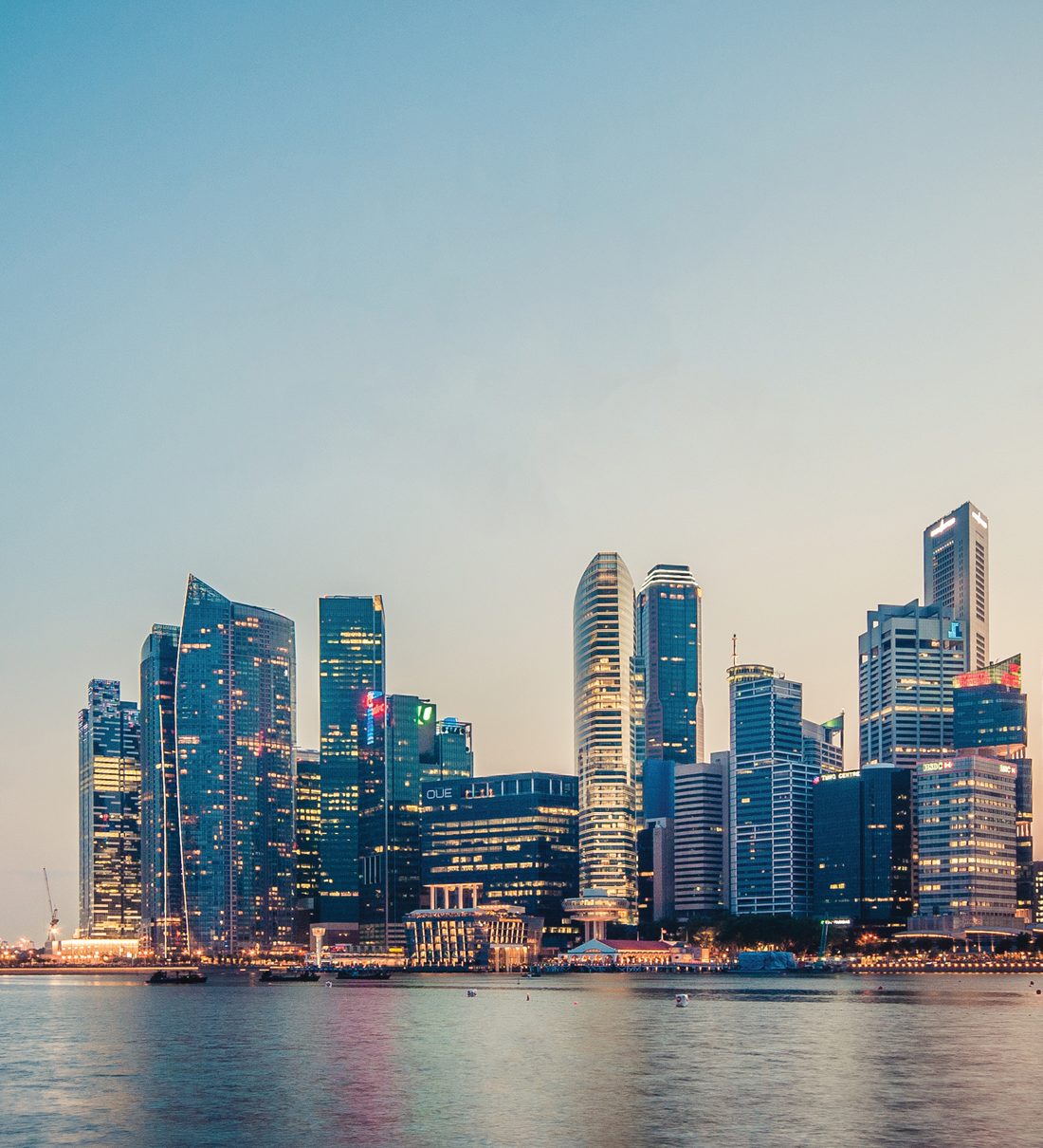 Singapore central business district at dusk — headquarters of the Pana Harrison group since 1980